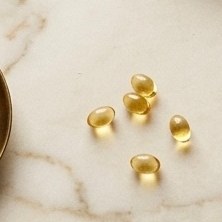 Small golden softgels on marble